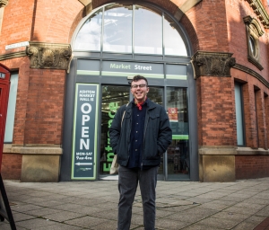 smiling person in front of shop